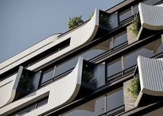 an apartment building with plants growing on the balconies