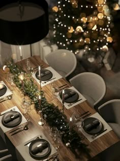 a table set for christmas dinner with silverware and candles