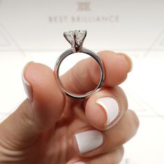 a person holding a diamond ring in their hand