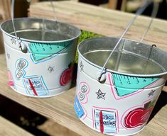 two buckets are sitting on a wooden bench with needles in them and one is empty