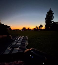 a person sitting on a blanket at sunset