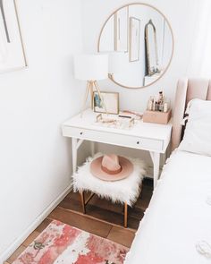 a white desk with a pink hat on top of it and a mirror in the corner