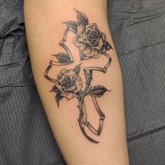 a cross tattoo with roses on it