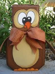 an owl statue with a bow on it's head sitting in front of some plants