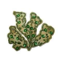 a green and white brooch sitting on top of a table