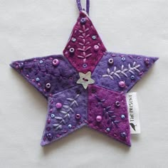 a purple star ornament hanging on a string