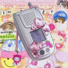 an old cell phone with pink bows on it's back and other cartoon characters around it