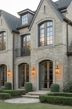 a large house with many windows and bushes