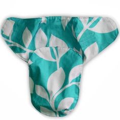 a blue and white leaf print cloth cover on top of a white tablecloth with a green background