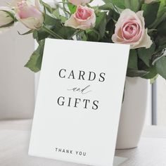 a card with the words cards and gifts written on it next to some pink roses