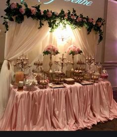 a table topped with lots of desserts under a neon sign