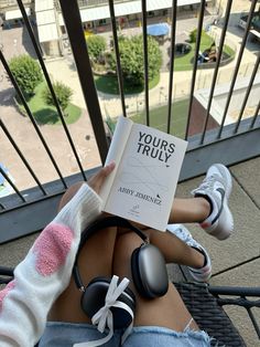 a person sitting on a balcony reading a book