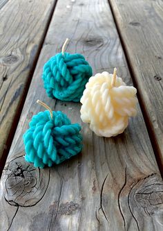 two blue and white yarn balls sitting on top of a wooden table next to each other