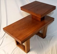 two wooden tables sitting on top of each other in front of a white background,