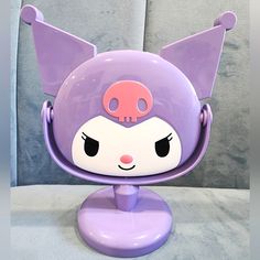 a purple and white animal head on top of a stand