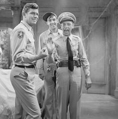 three men in uniform standing next to each other and one is giving the peace sign