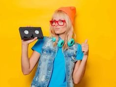 a woman wearing glasses holding up a video game controller