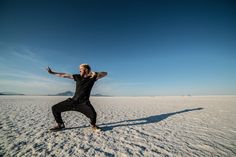 a man standing in the middle of a desert with his arms out and hands outstretched