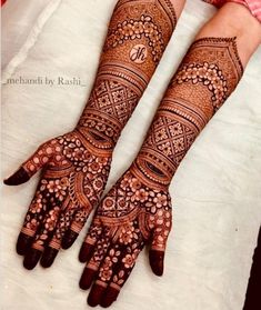 two hands with henna designs on them, one is showing it's intricate design