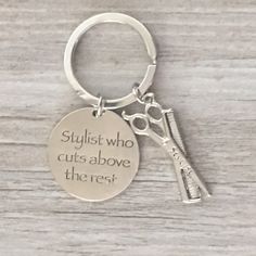 a pair of scissors sitting on top of a keychain that says, stylist who cuts above the rest