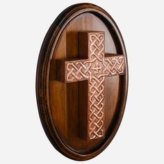 a wooden plaque with a cross carved into the front and sides, on a white background