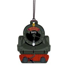 an ornament shaped like a train engine hanging from a string on a white background