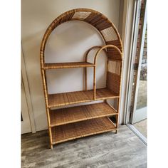 a wicker shelf with two shelves on each side and a door in the background