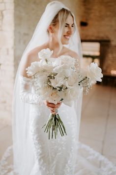 a woman in a wedding dress holding a bouquet of flowers