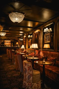 a dimly lit restaurant with chandeliers and chairs