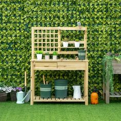 an outdoor garden area with potted plants and a wooden bench in front of a green wall