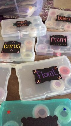 four plastic containers with labels on them sitting on a table next to some other items