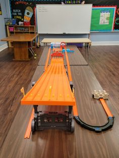 an orange toy roller coaster on a wooden floor