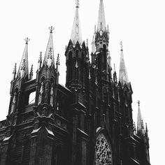 an old church with steeples and a clock on it's front tower is shown in black and white