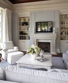 a living room filled with furniture and a flat screen tv mounted to a wall above a fire place