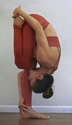 a woman is doing a handstand on the floor