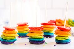 rainbow desserts stacked on top of each other with toothpicks sticking out of them