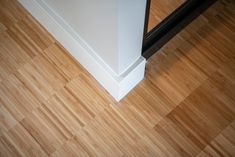 an overhead view of a wood floor and white door frame with black handle on it