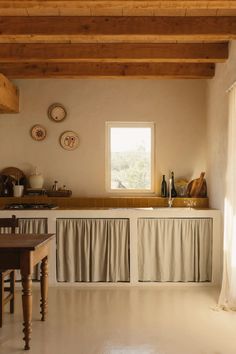 a kitchen with white floors and wooden ceiling