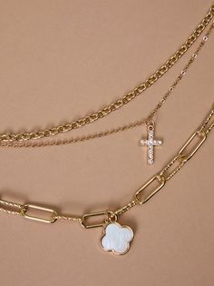 Faith and fashion meet in this layered necklace. Three delicate chains showcase a shimmering mother-of-pearl clover, a golden cross, and sparkling crystals, offering a statement piece for any occasion. Golden Cross, Cross Necklaces, Floral Shop, A Cross, Mini Dress Shop, Accessories Jewelry Necklace, Altar'd State, Layered Necklace, Sparkling Crystal