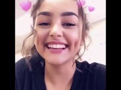 a girl with pink hearts on her head smiling