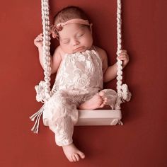 a baby is sleeping on a swing