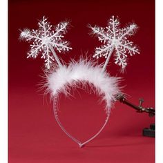 two snowflake headbands with white feathers on a red background in the shape of a heart