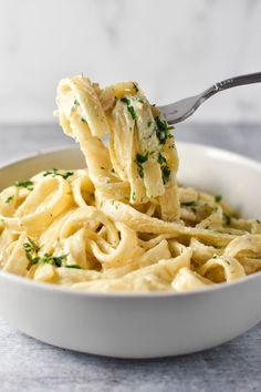 creamy bourssin pasta in a white bowl with a spoon