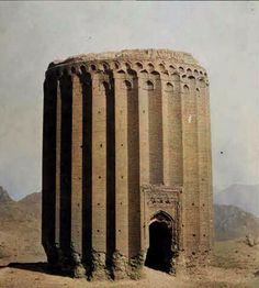 an old brick building in the desert with mountains in the backgrouds behind it