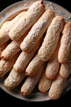 a white plate topped with lots of powdered sugar covered donuts