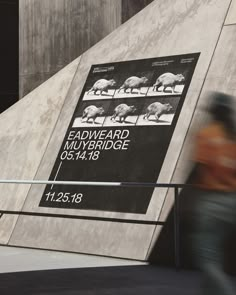 a person walking past a sign on the side of a building