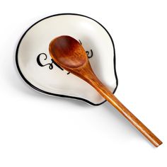 a wooden spoon sitting on top of a white plate next to a black and white border