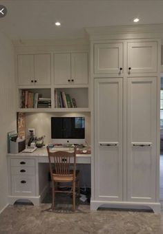 a home office with built in cabinets and desk