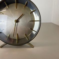 an analog clock sitting on top of a table