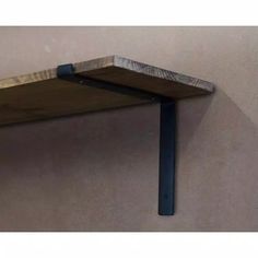 a close up of a shelf on the wall with a metal bar attached to it